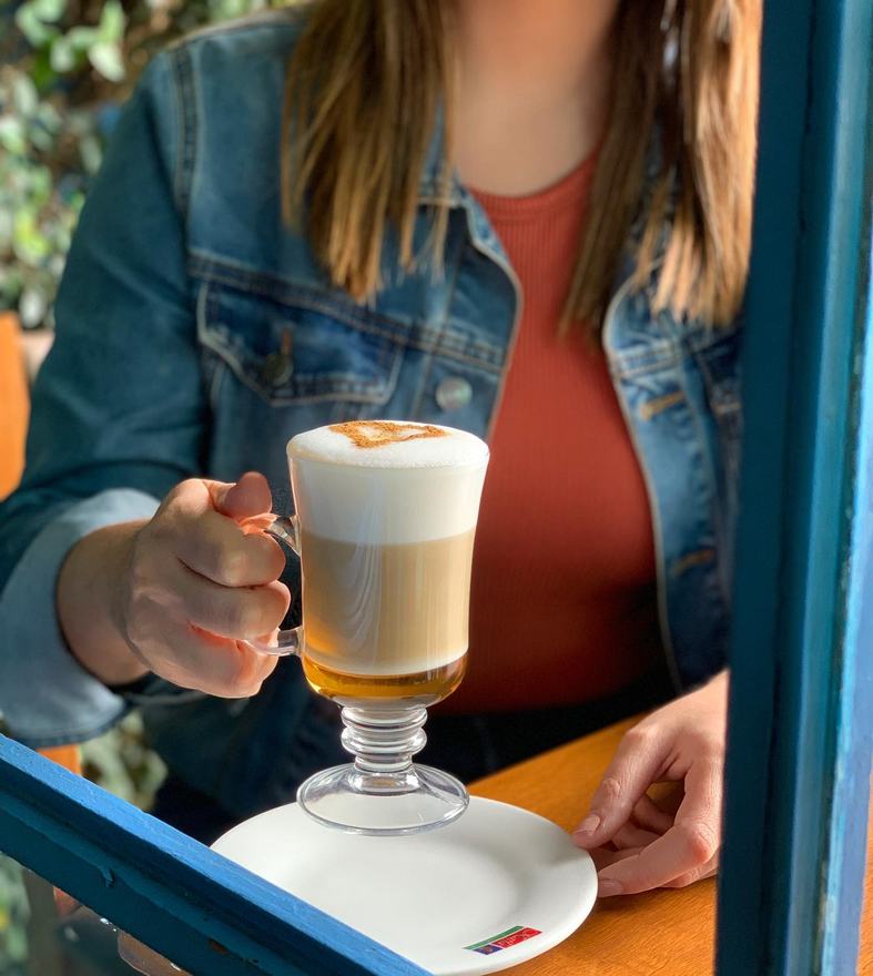 Capuccino servido en la mesa de una clienta