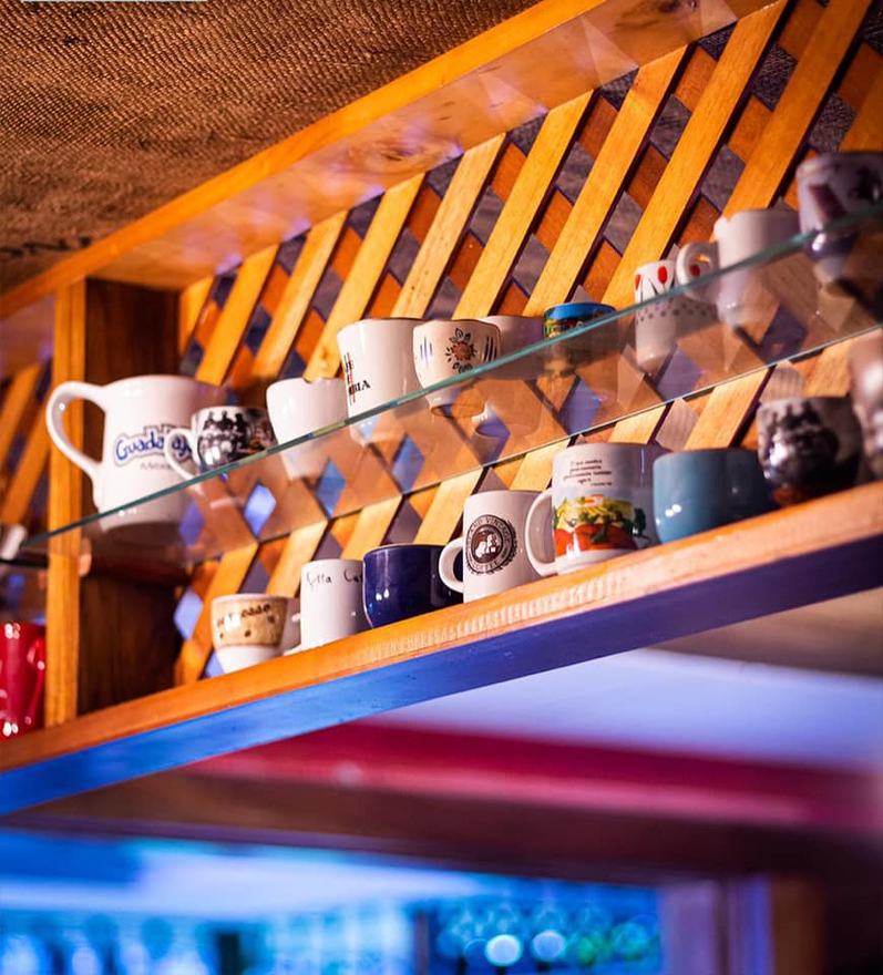 Estante de tazas en el salón de Kaffa Café